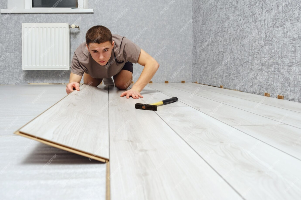 jeune-homme-reparateur-pose-panneau-bois-sol-stratifie-interieur-plancher-flottant-espace-copie-mise-au-point-selective-85601-492